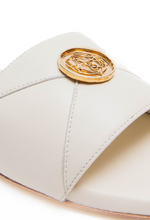 Load image into Gallery viewer, White sandal with a gold emblem on a white background
