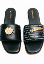Load image into Gallery viewer, Black sandals with gold accents on a white background
