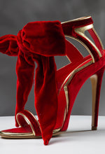 Load image into Gallery viewer, Red high-heeled shoe with gold accents and a large red bow on a gray background
