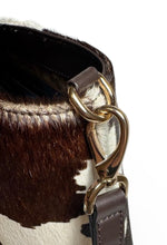 Load image into Gallery viewer, Close-up of a cowhide leather handbag with a gold clasp on a white background
