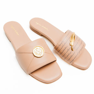 Pair of beige slides with gold accents on a white background